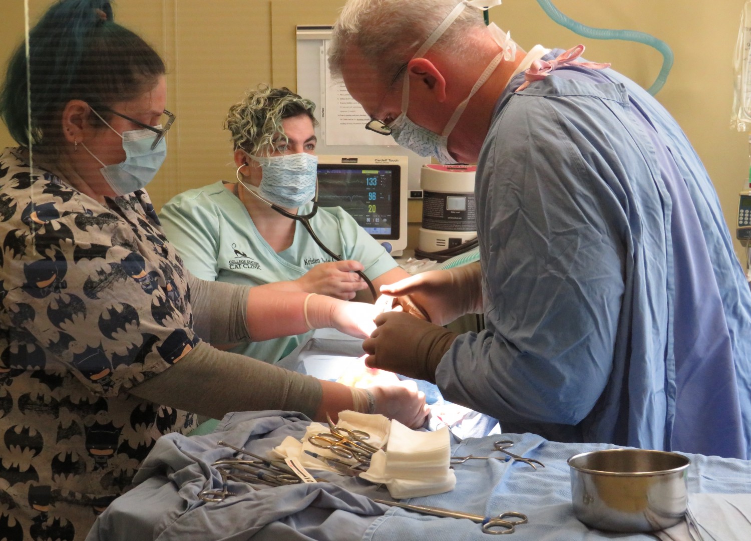 Two Technicians and Doctor performing surgery on a patient